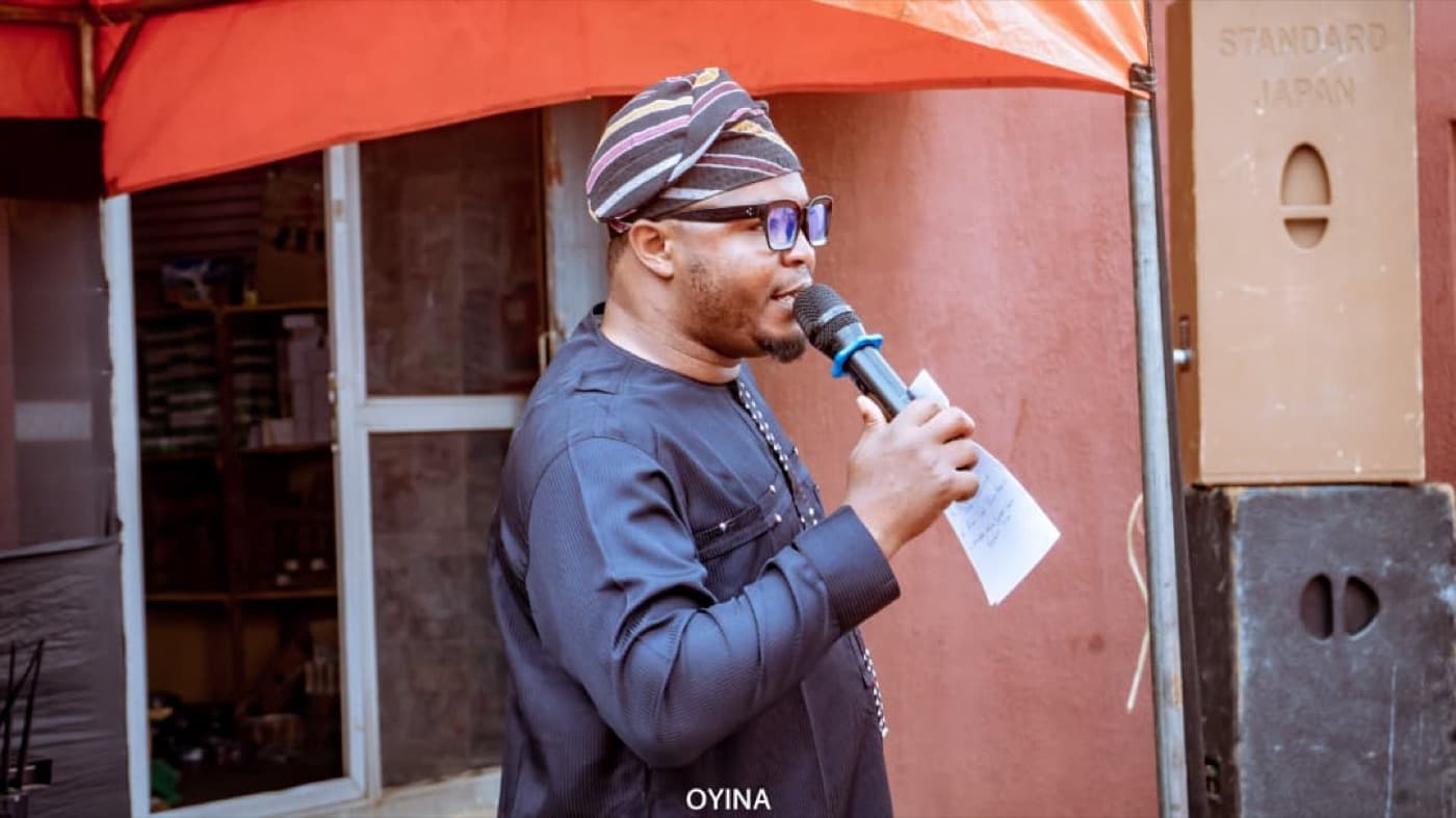 An event host speaking into a microphone at an OYNA program